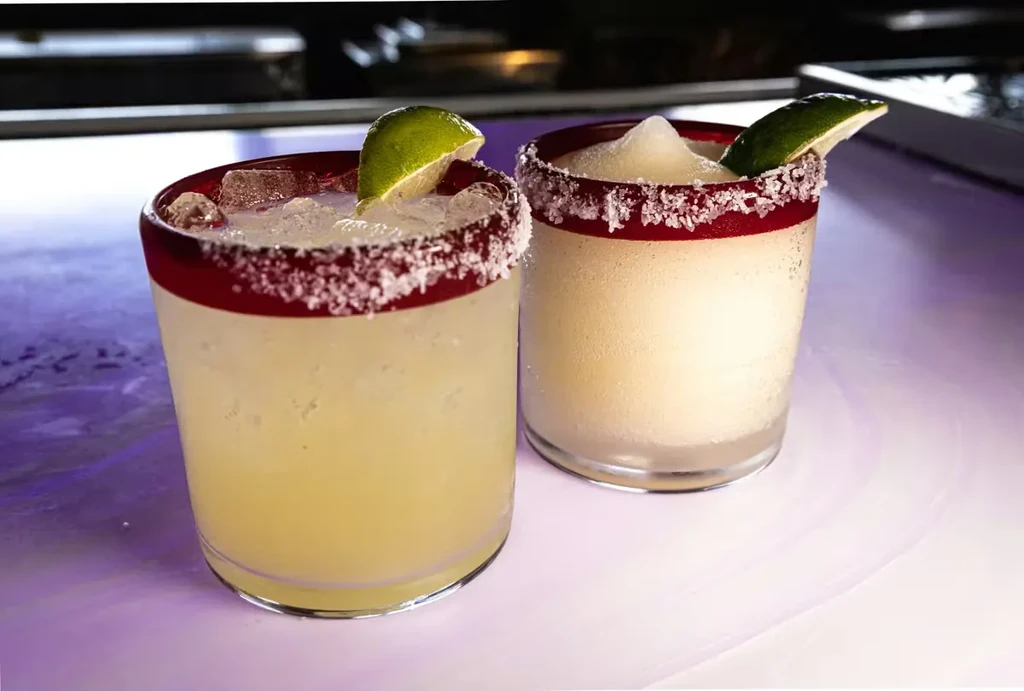 Two margaritas: one liquid, one frozen, both with red salted rims.
