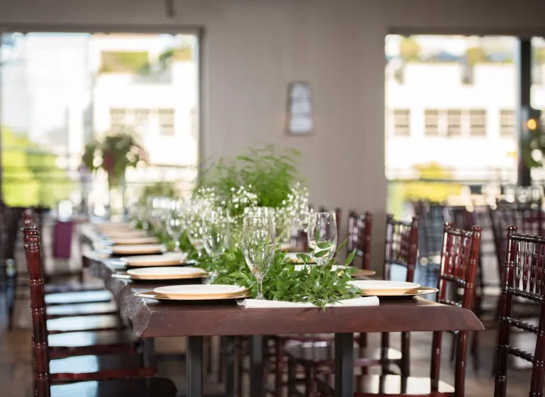 Elegant dark wood dining table with floral centerpiece and place settings.