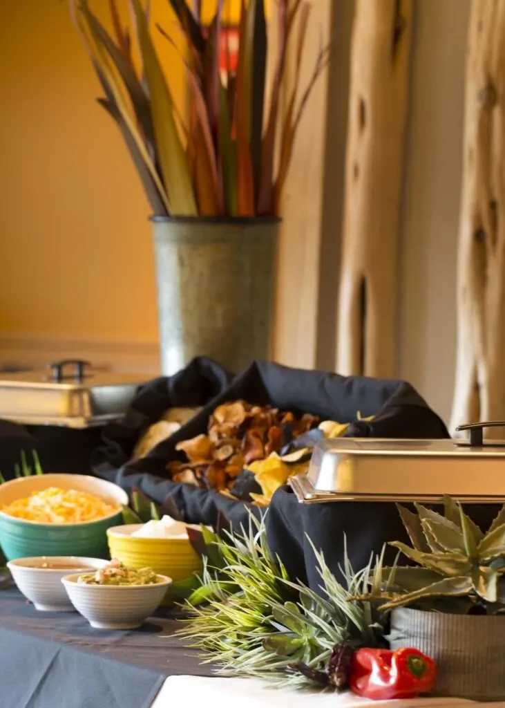 Mexican buffet: dips, tortilla and root vegetable chips, warming dishes.