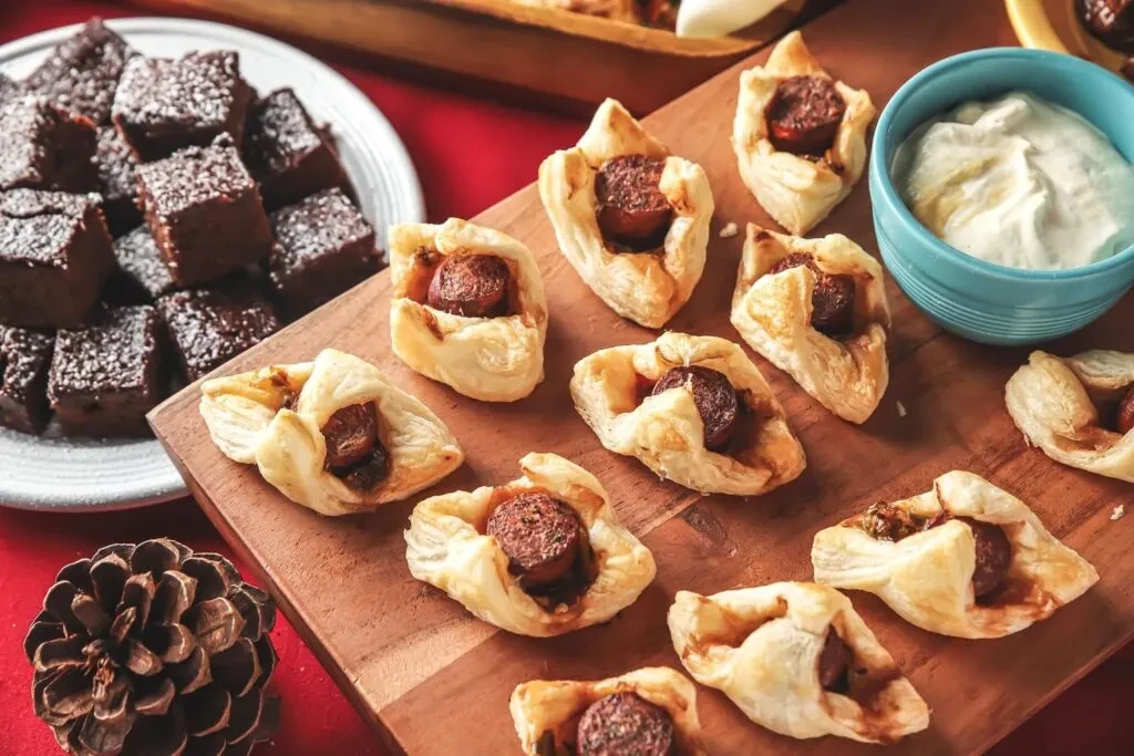 Pastry-wrapped meat appetizers, creamy dip, and chocolate brownies.
