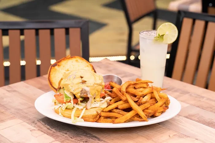 Open-faced burger, french fries, and a lime drink on a table.