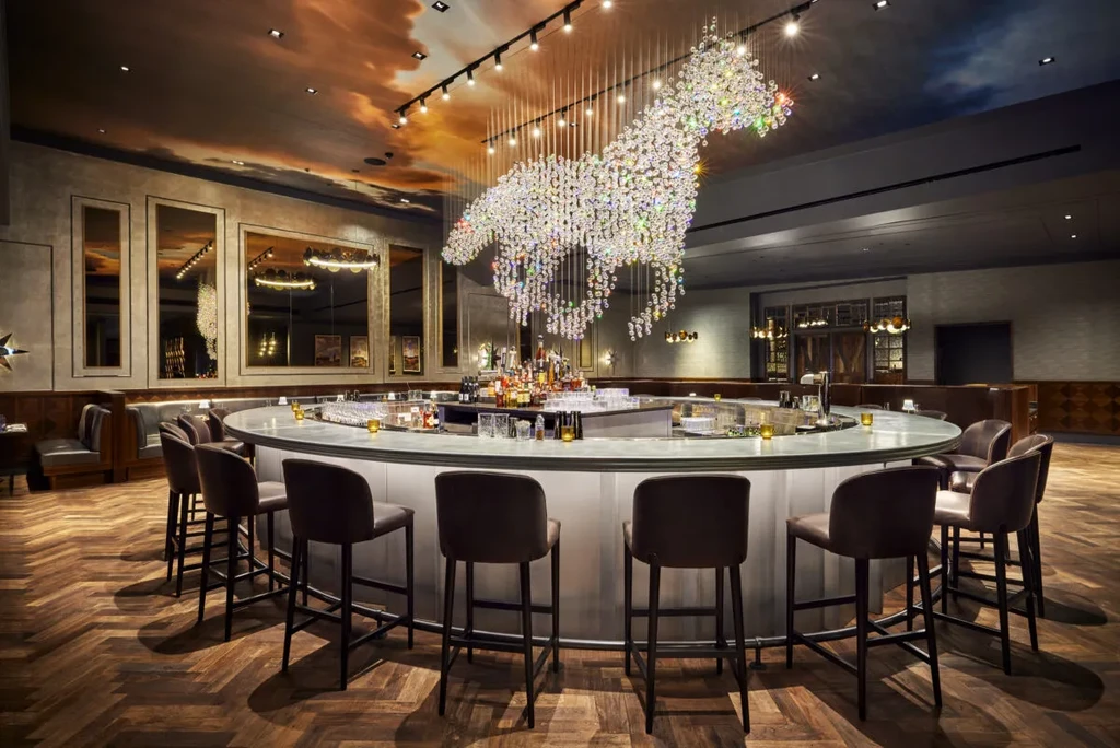 Circular bar with crystal horse chandelier and ceiling mural.