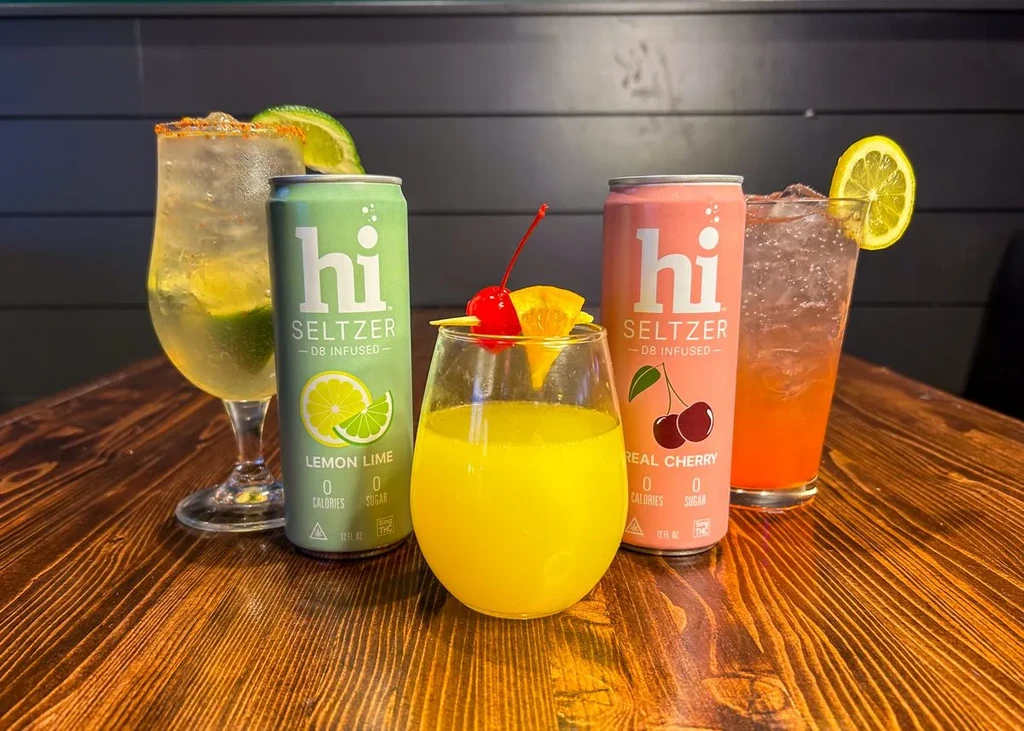 Five D8-infused seltzers and beverages on a wooden table.