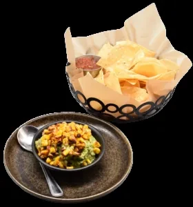 Guacamole with roasted corn, tortilla chips, and red salsa.
