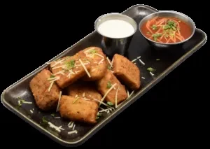 Golden-brown fried snacks with two sauces on a dark gray platter.