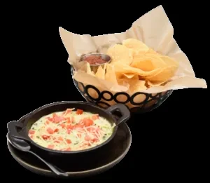 Basket of tortilla chips with salsa, skillet of creamy dip with toppings.