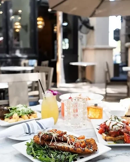 Gourmet food and drink served on an outdoor restaurant table.