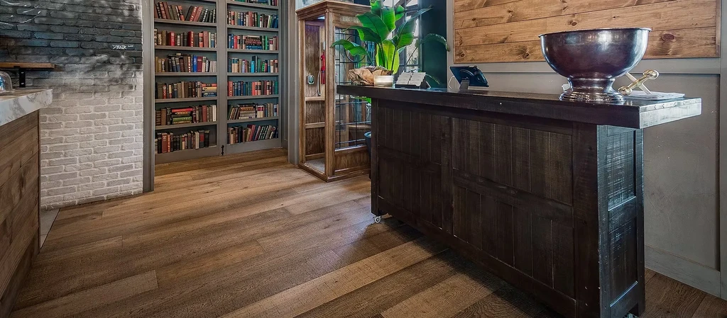 Cozy restaurant lounge with a large bookcase, brick wall, and wood counters.