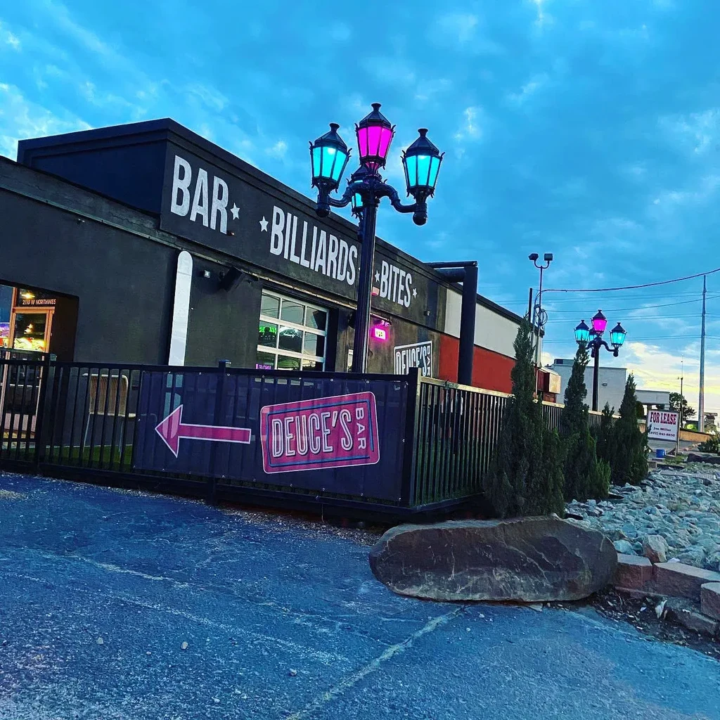 Deuce's Bar sign, "BAR BILLIARDS BITES," with cyan and magenta lights.