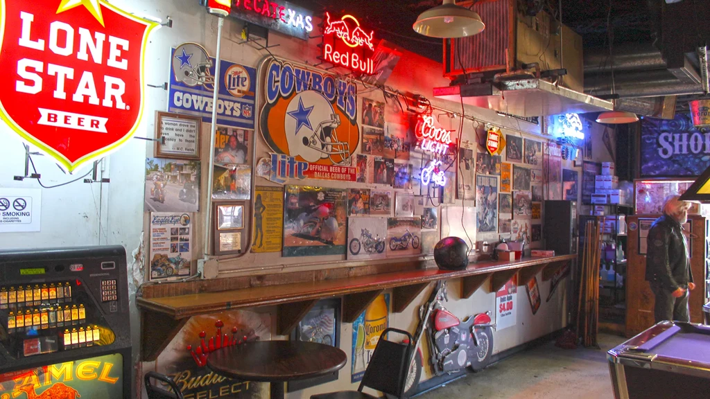 Vibrant bar interior decorated with many brand neon signs and posters.