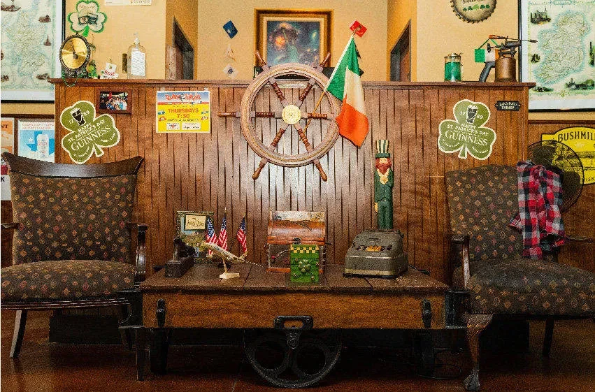 Heavily decorated pub interior with ship's wheel, Irish flag, and themed items.