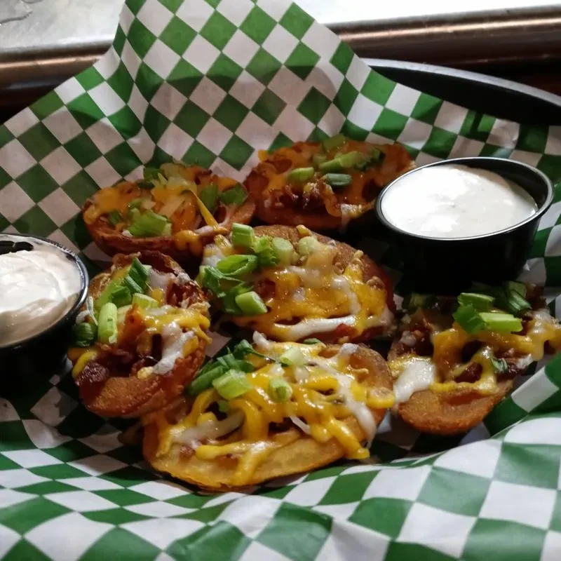Basket of six loaded potato skins with cheese, bacon, and scallions.