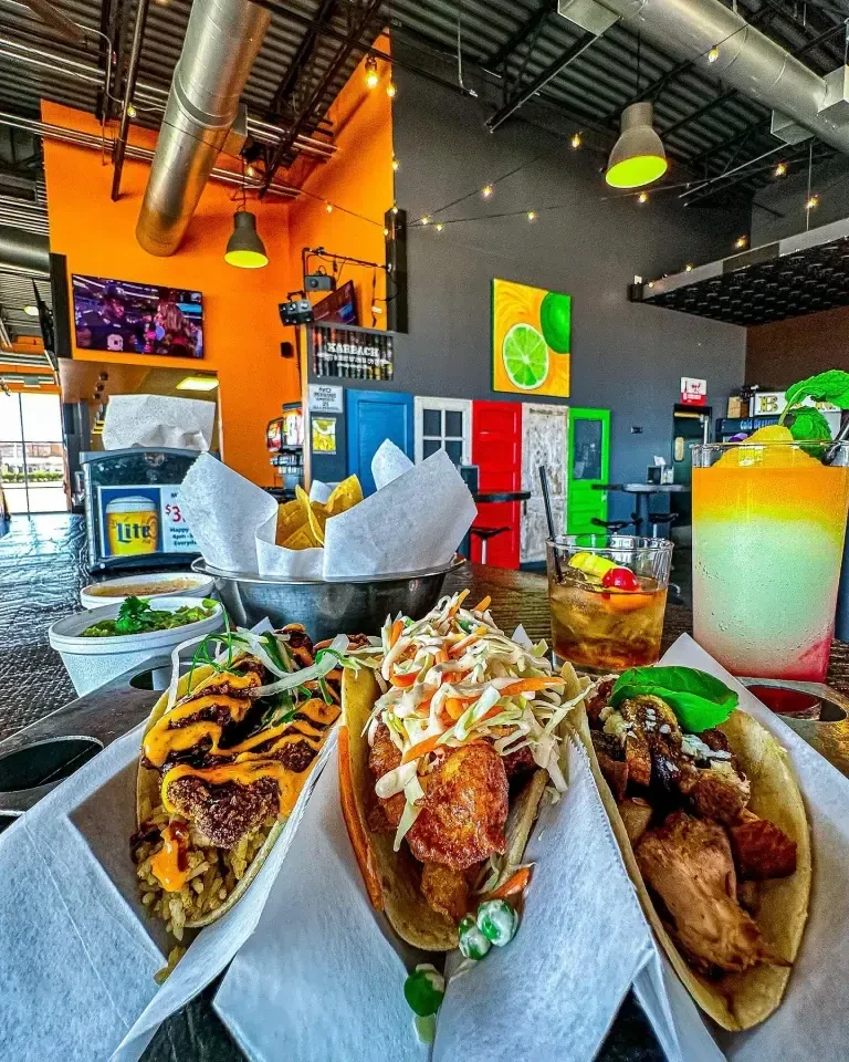 Tacos, chips, guacamole, and cocktails in a vibrant restaurant setting.