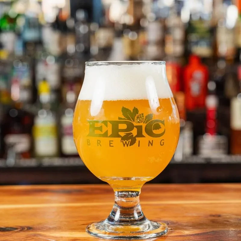 EPIC BREWING golden beer in a tulip glass on a bar counter.