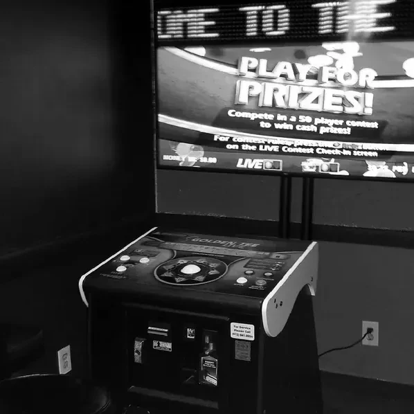 Black and white photo of Golden Tee arcade machine, 'PLAY FOR PRIZES!' on screen.