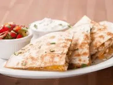 Quesadillas with visible melted cheese, salsa, and creamy dip on a white plate.