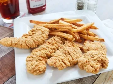 Crispy fried chicken tenders and golden french fries on a white plate.