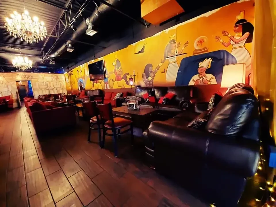 Ancient Egyptian themed bar interior with vibrant murals and comfortable seating.
