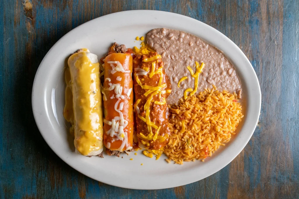 Mexican meal with enchiladas, refried beans, and Spanish rice.