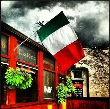 Red pub with Italian flag and Irish welcome sign.