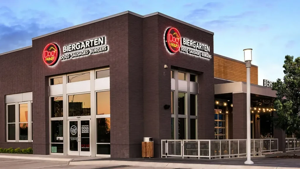 Modern Dog Haus Biergarten exterior: dark brick, large windows, outdoor patio.
