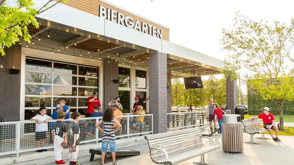 Modern Biergarten patio bustling with families on a sunny day.