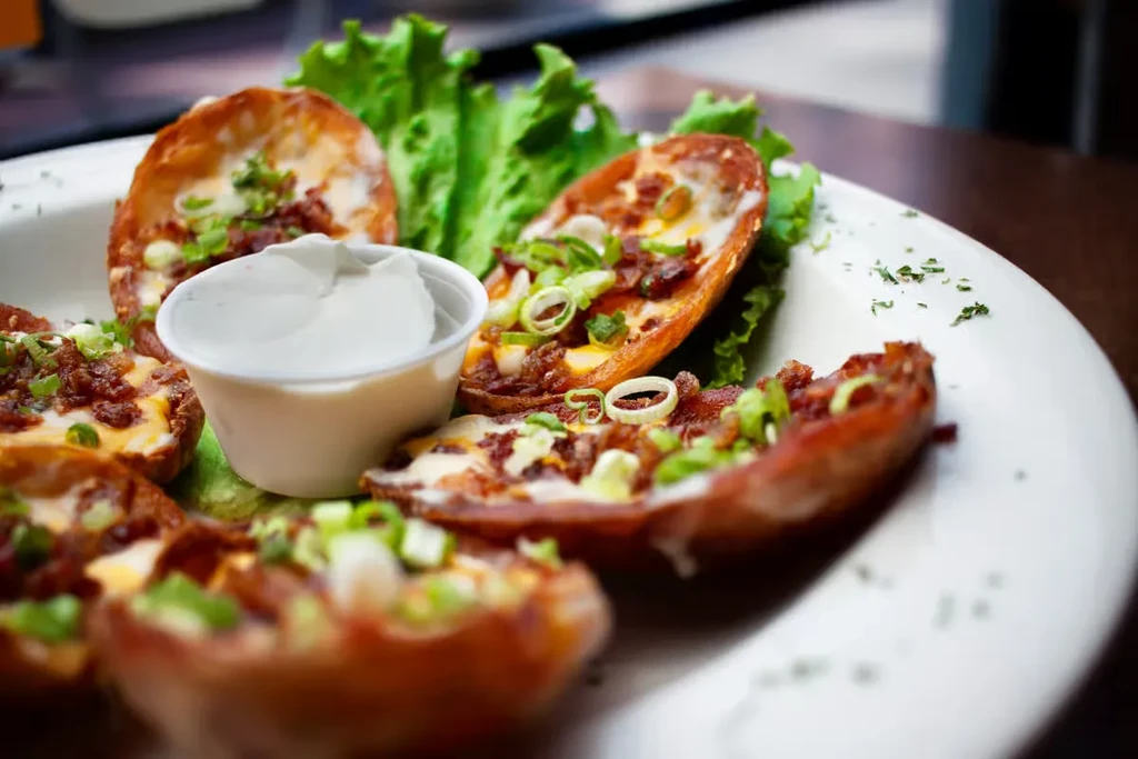 Potato skins filled with cheese, bacon, green onions, served with sour cream.