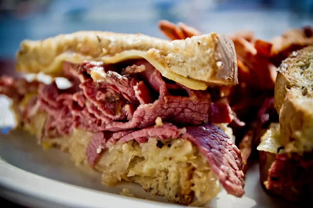 Thick pastrami or corned beef sandwich with sauerkraut and fries.