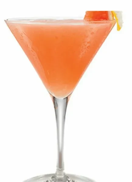 Frosty orange-pink cocktail in martini glass, citrus garnish, white background.