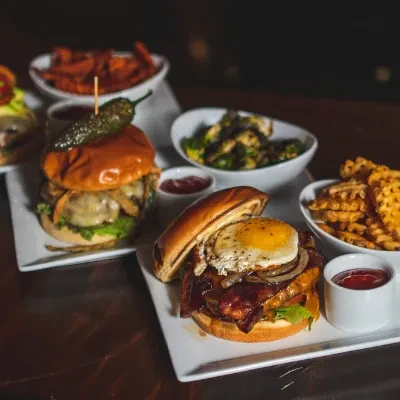 Two gourmet burgers: one with egg, bacon; one with jalapeño, cheese.