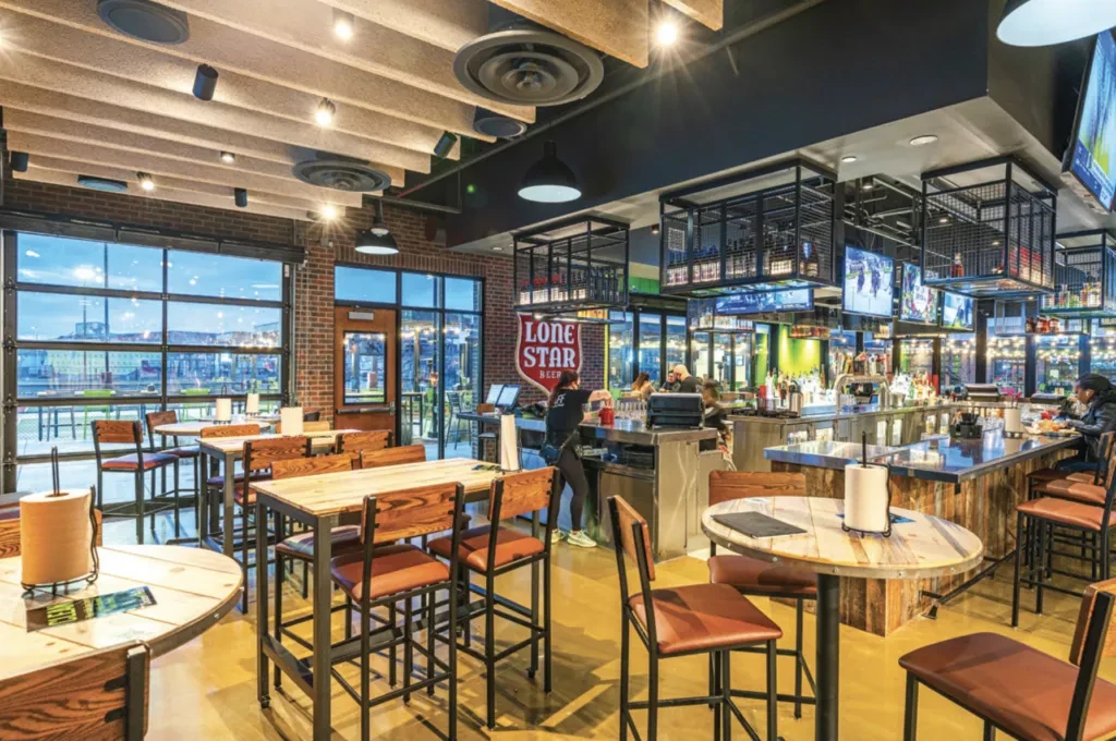Modern industrial restaurant and bar with brick walls and high tables.