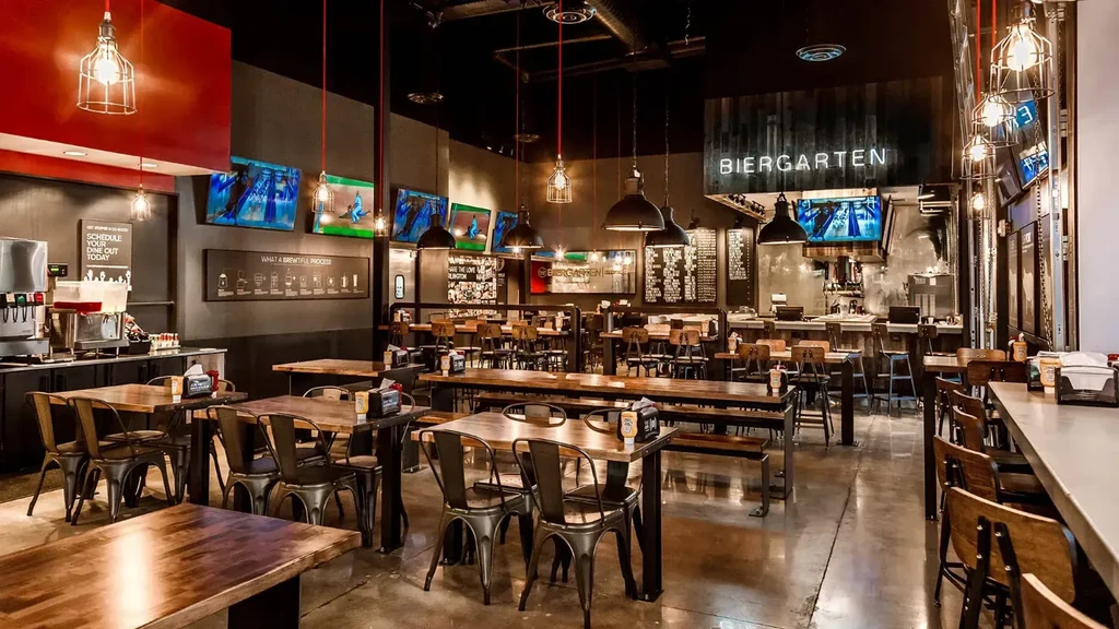 Empty modern Biergarten interior, industrial-chic, with bar and televisions.