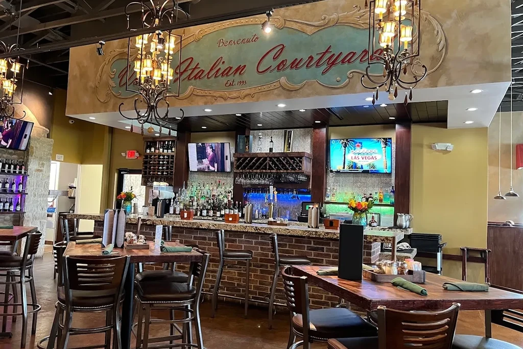 Benvenuto Italian restaurant bar and dining area with brickwork and TVs.