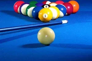 Full rack of billiard balls, cue ball, stick on blue pool table.