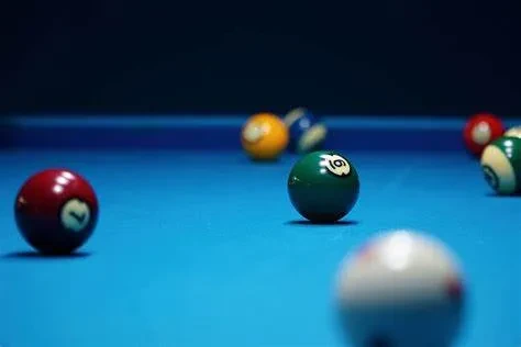 Green 6-ball and red 7-ball scattered on a blue pool table.