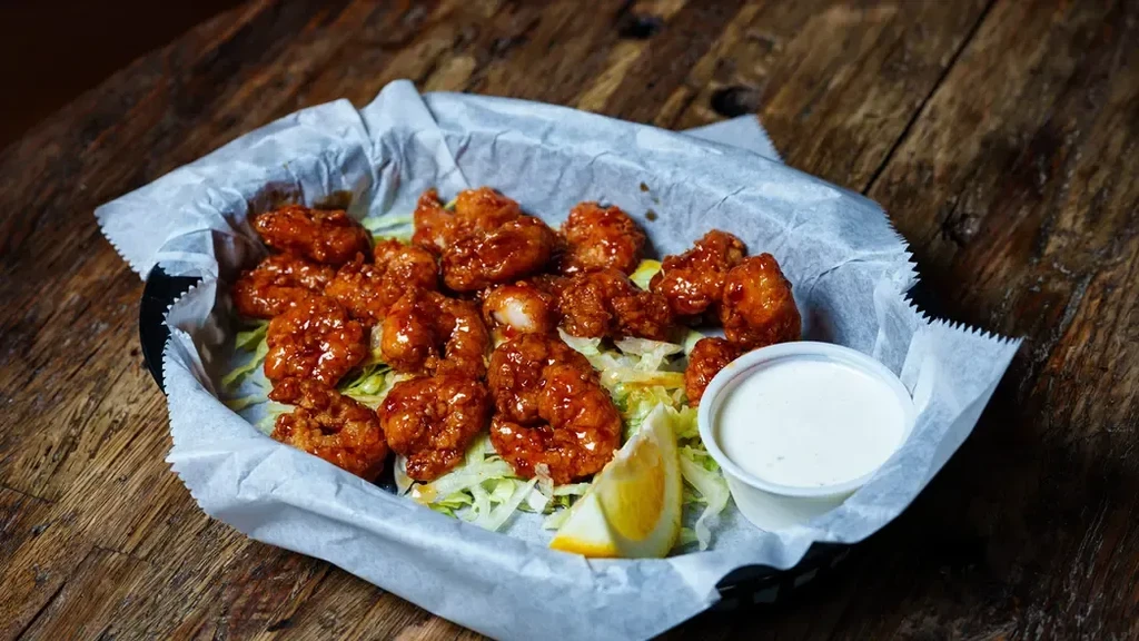 Fried chicken/shrimp in reddish-orange sauce with lettuce, lemon, and dip.