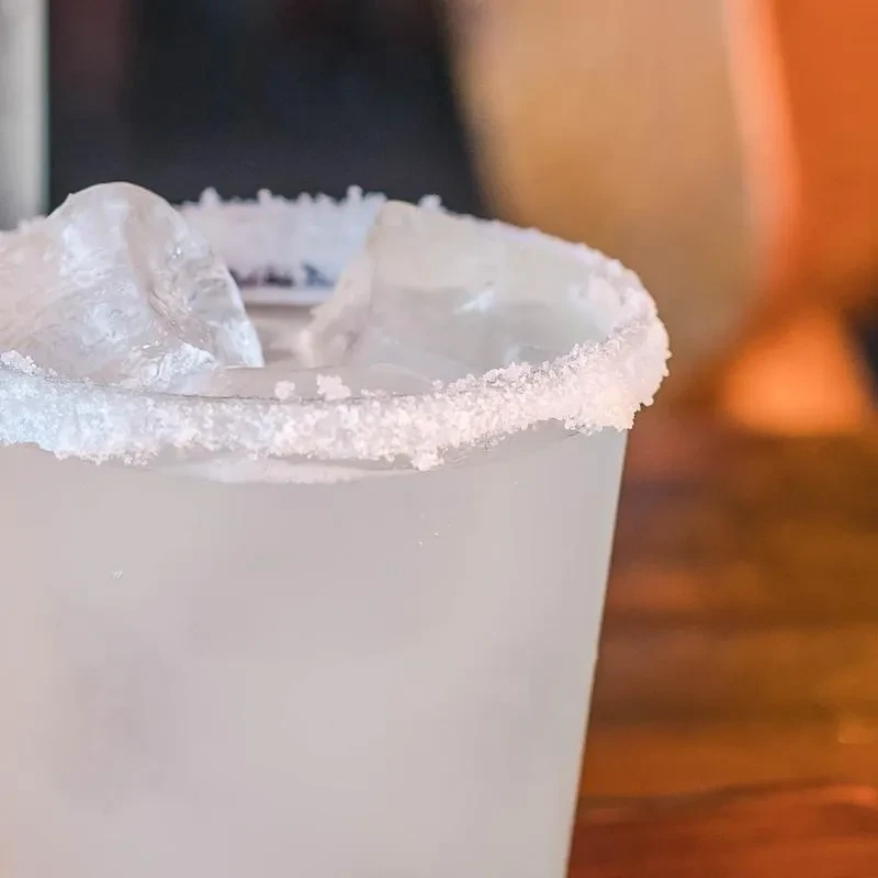 Frosted glass drink with thick salted rim and ice cubes.
