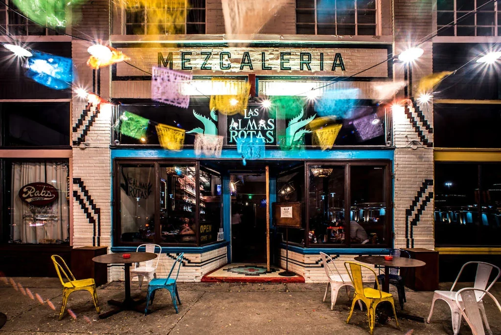 Mezcaleria Las Almas Rotas exterior, brightly lit with colorful decorations.