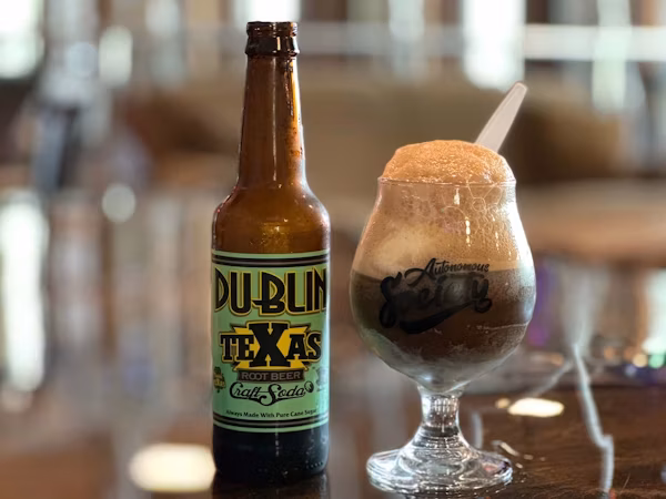 Dublin Texas root beer bottle and a foamy drink with a spoon.