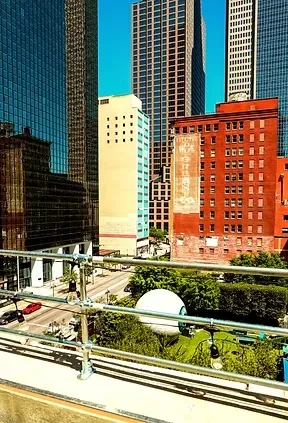 Panoramic view of a sunny city skyline with modern and old buildings.