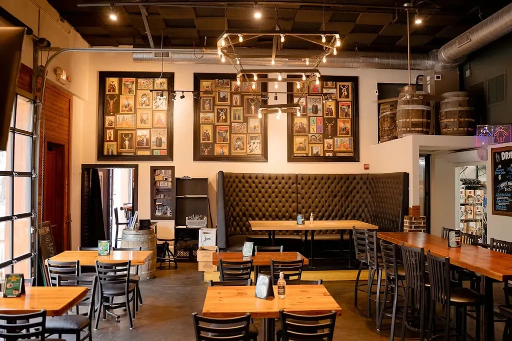Modern rustic industrial restaurant interior with empty tables and banquettes.