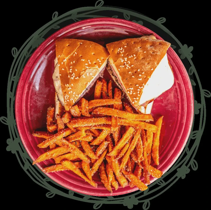Overhead shot: half sandwich, sweet potato fries on red plate.