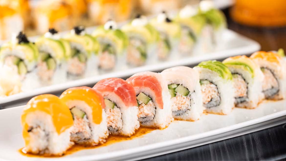 Plates of colorful sushi rolls with various toppings.