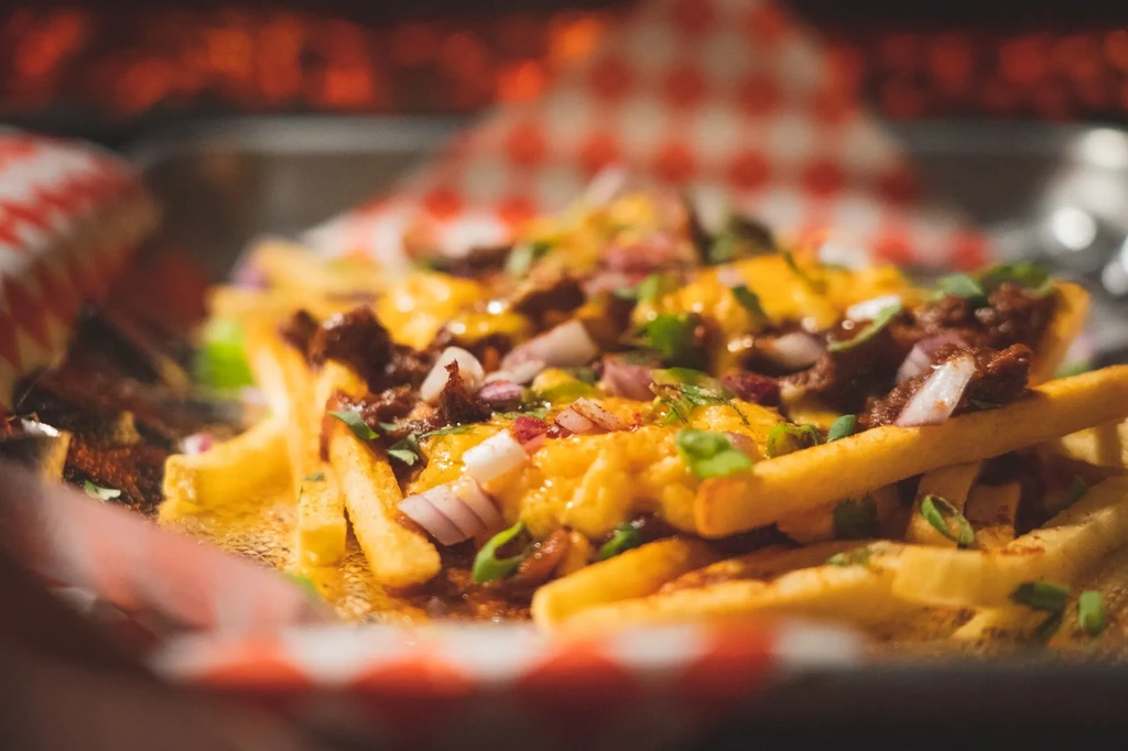 Loaded french fries with melted cheese, chili, red and green onions.
