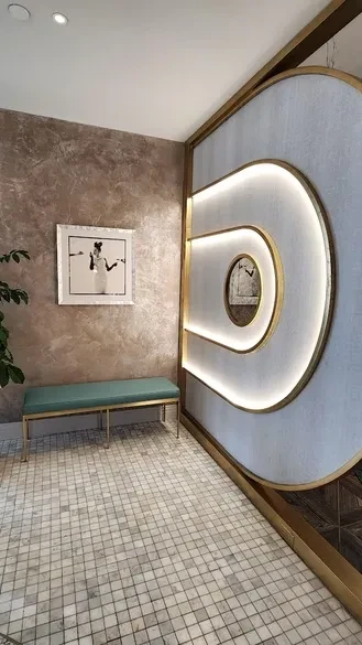 Modern interior with teal bench, framed art, and illuminated curved wall.