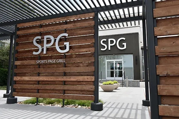 SPG Sports Page Grill's modern entrance with wooden sign.