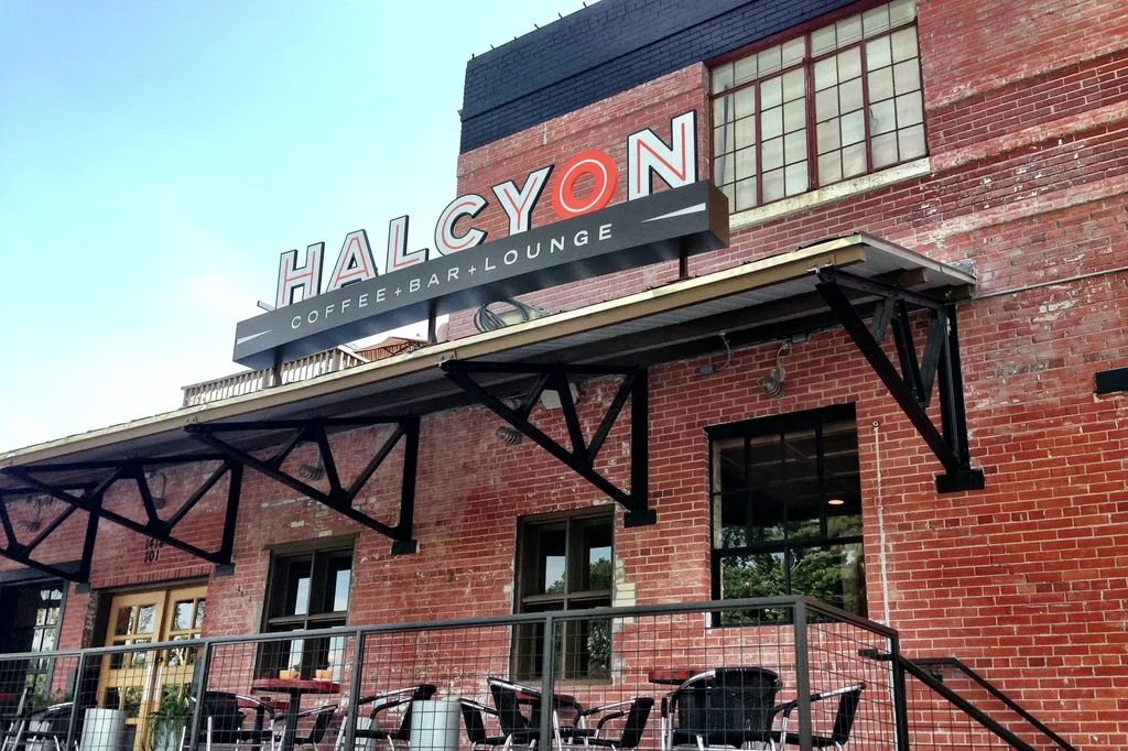 Exterior of Halcyon Coffee+Bar+Lounge, a red brick building with patio.