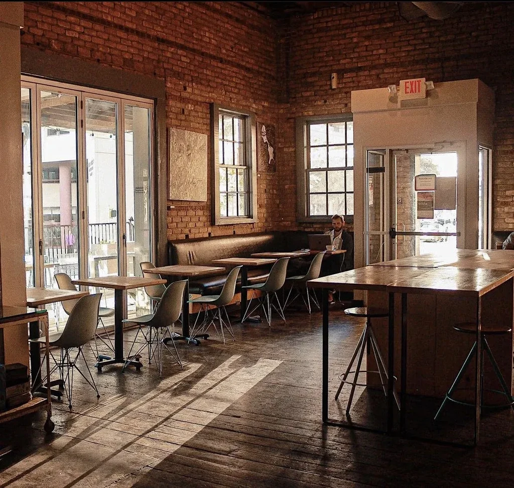Industrial-chic restaurant interior with brick, wood, and modern seating.