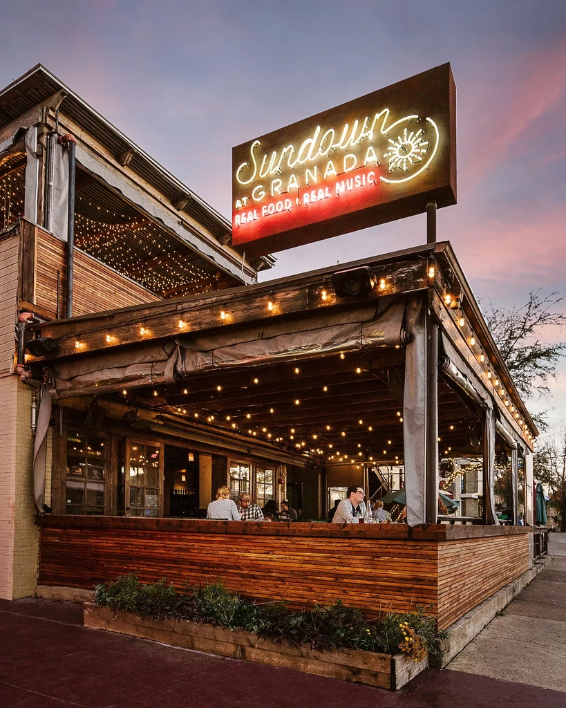 Sundown at Granada patio, glowing with neon sign at dusk.