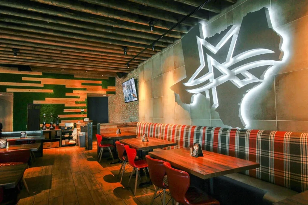 Rustic modern restaurant interior with a plaid booth and Texas sign.